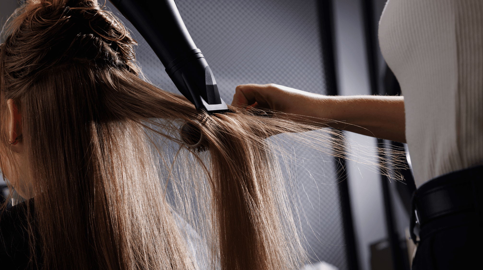 coiffeur séchant les cheveux avec sèche-cheveux et peigne dans le salon de beauté, sèche-cheveux en gros plan, concept d'autosoin